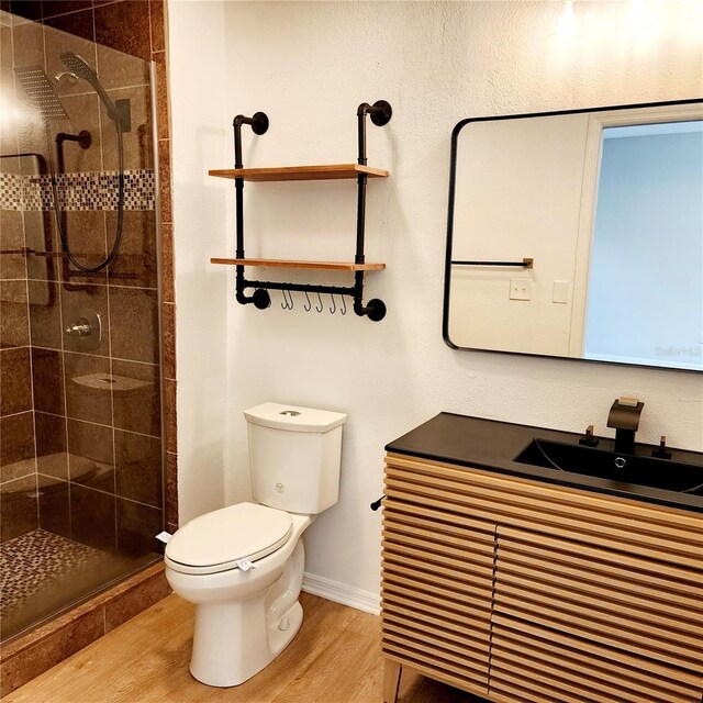 bathroom with hardwood / wood-style flooring, vanity, toilet, and an enclosed shower