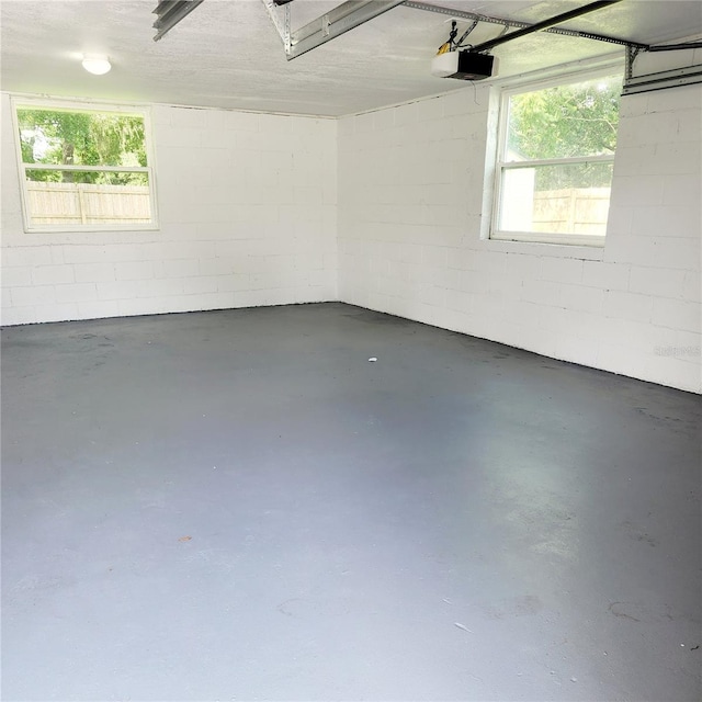 garage with concrete block wall and a garage door opener