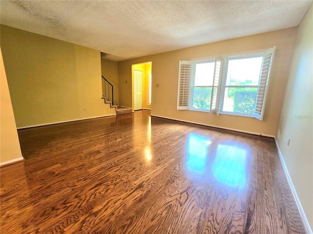 spare room with a textured ceiling and hardwood / wood-style flooring