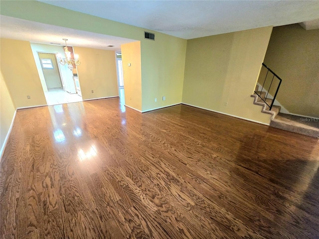 spare room with hardwood / wood-style floors and a chandelier