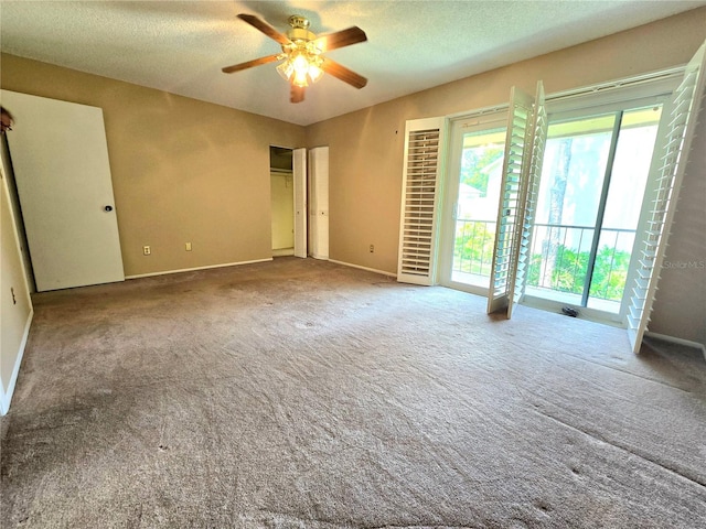 carpeted empty room featuring ceiling fan and a textured ceiling