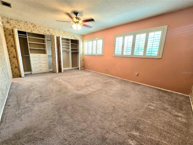 unfurnished bedroom with ceiling fan, carpet floors, and a textured ceiling