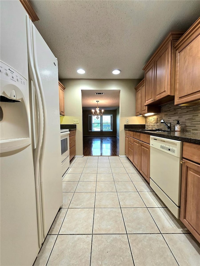 1019 Grove St Unit 85, Maitland, FL 32751 - kitchen featuring a textured ceiling, light tile patterned floors, dark countertops, an inviting chandelier, and white appliances