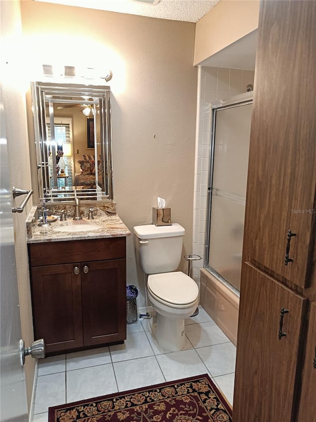 full bathroom with tile patterned flooring, vanity, combined bath / shower with glass door, and toilet