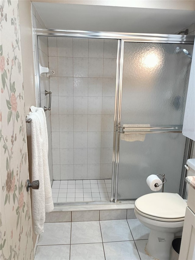 bathroom featuring tile patterned flooring, vanity, an enclosed shower, and toilet