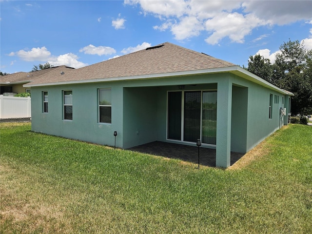 rear view of property featuring a lawn