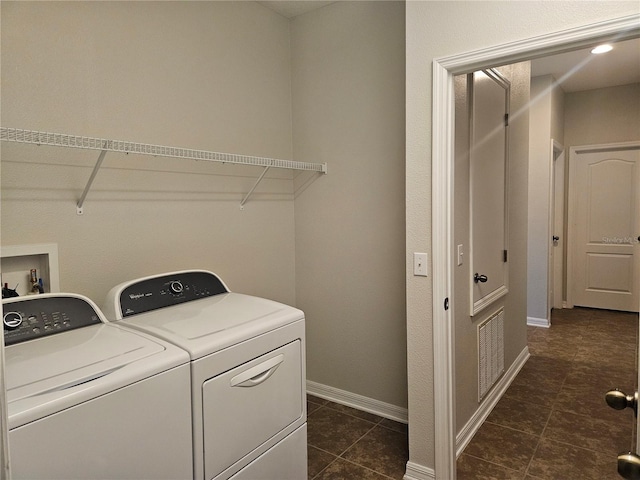 washroom with separate washer and dryer and dark tile patterned flooring