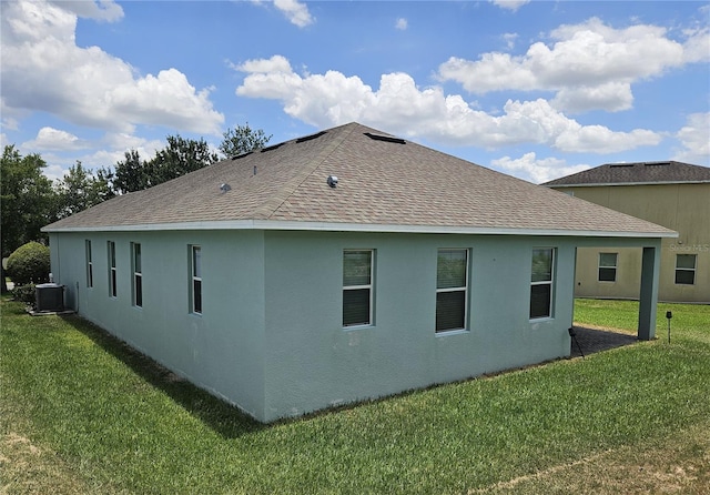 view of home's exterior featuring central AC unit and a lawn