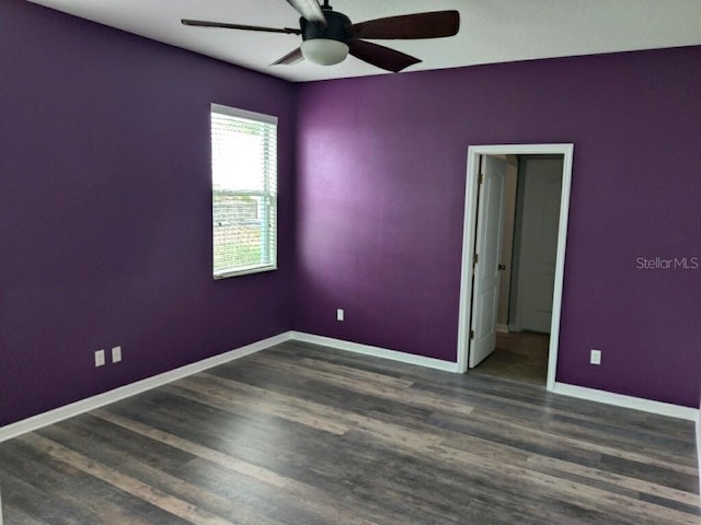 spare room with dark wood-type flooring and ceiling fan