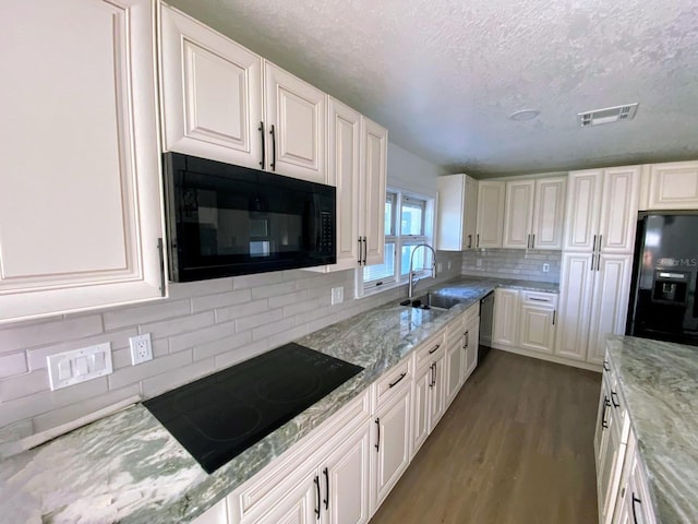 kitchen with black appliances, white cabinets, and sink