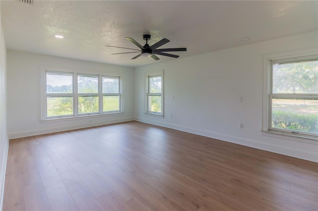 empty room with a textured ceiling, light hardwood / wood-style flooring, and ceiling fan