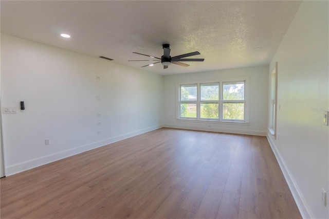 spare room featuring ceiling fan, a textured ceiling, and light wood-type flooring