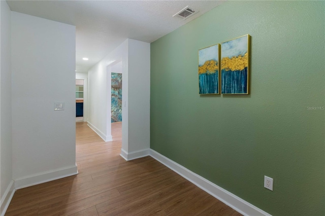 corridor with hardwood / wood-style floors