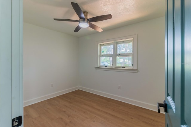 spare room with ceiling fan, light wood-type flooring, and a textured ceiling