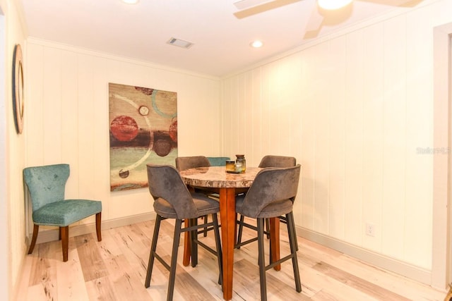 dining area featuring wood-type flooring and ornamental molding