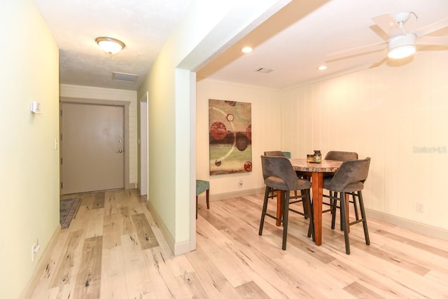 dining space featuring crown molding, ceiling fan, and light wood-type flooring