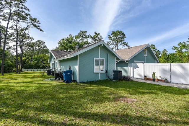 back of house featuring a yard and central air condition unit