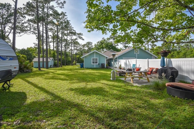 view of yard with a storage shed and a patio