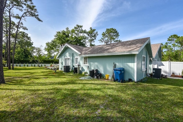 back of house with a yard and central AC