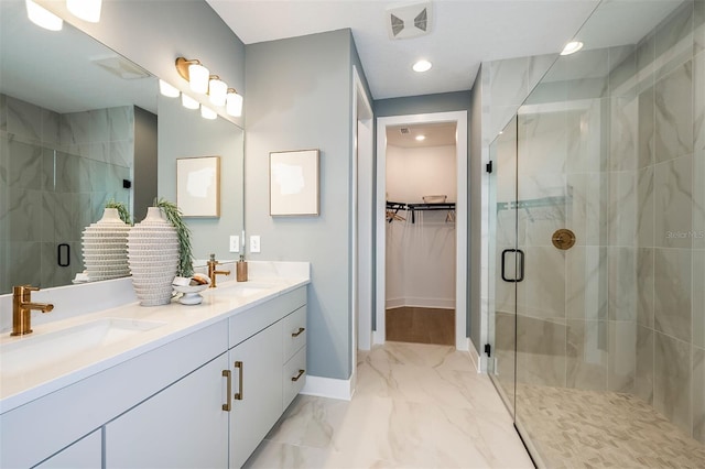 bathroom with a stall shower, marble finish floor, a sink, and a spacious closet