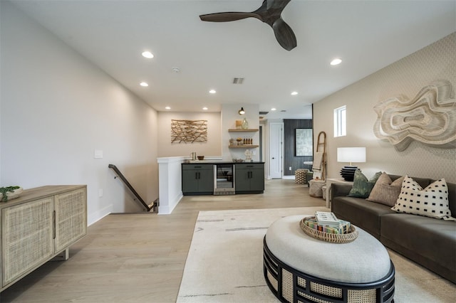 living area featuring wine cooler, indoor wet bar, light wood-style floors, and wallpapered walls