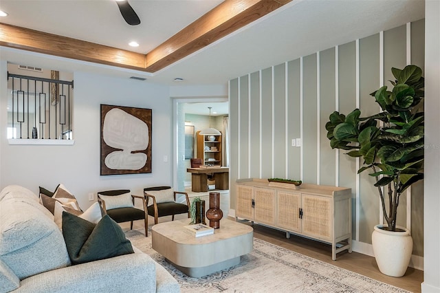 living area featuring recessed lighting, a raised ceiling, visible vents, and wood finished floors