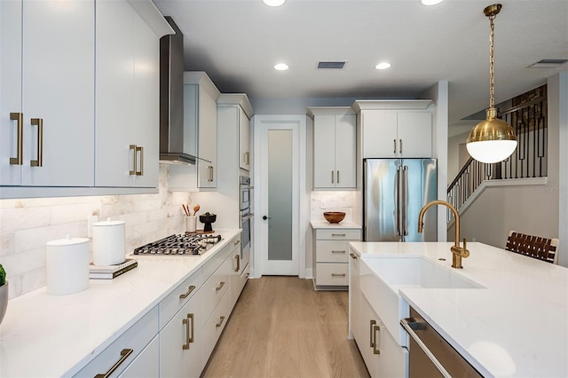 kitchen with visible vents, light stone countertops, stainless steel appliances, white cabinetry, and pendant lighting