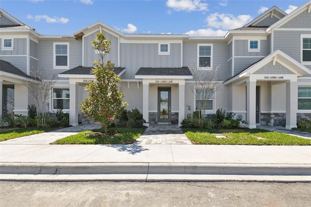 townhome / multi-family property featuring board and batten siding and roof with shingles