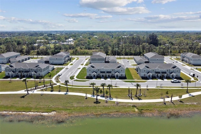 aerial view featuring a wooded view, a residential view, and a water view