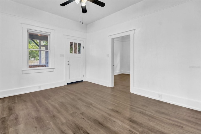 empty room with ceiling fan and dark hardwood / wood-style floors