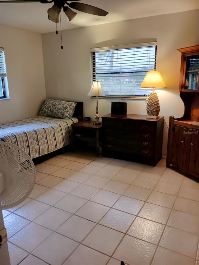 bedroom featuring ceiling fan, light tile patterned floors, and multiple windows