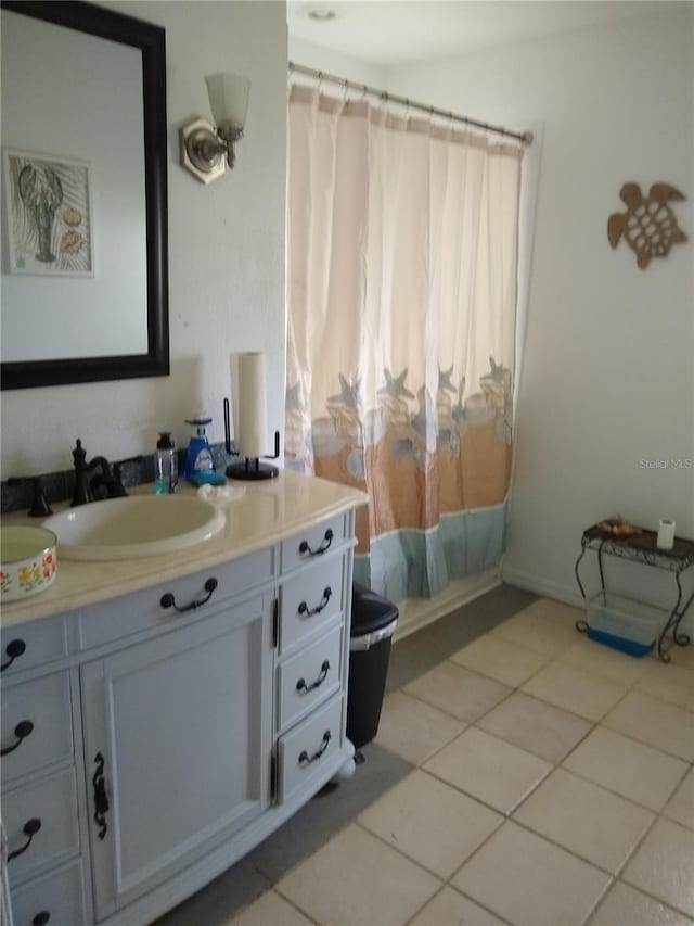 bathroom with vanity, toilet, curtained shower, and tile patterned flooring