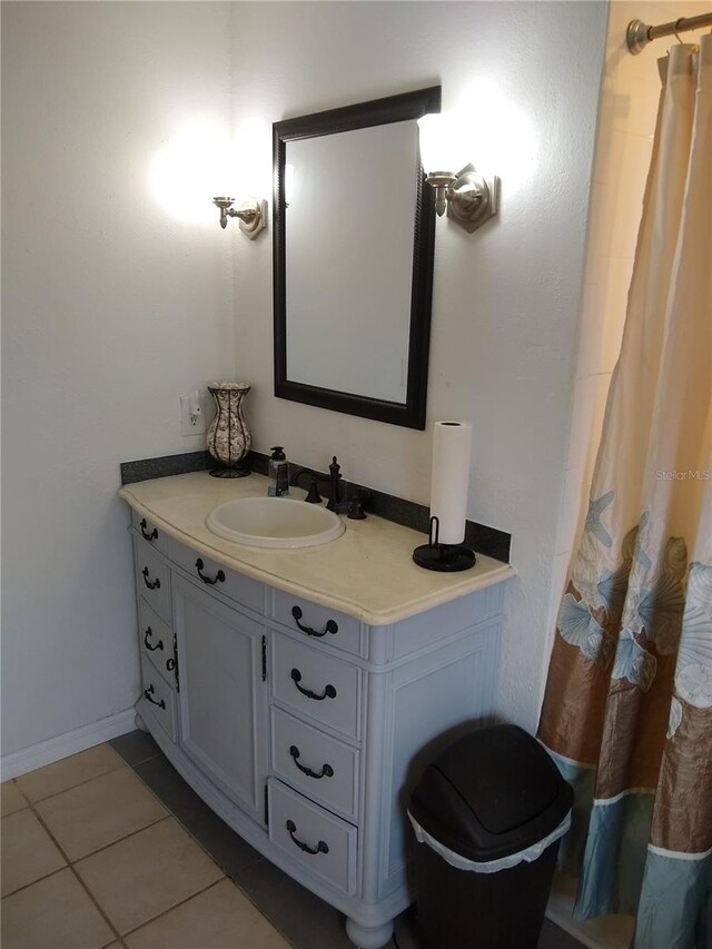 bathroom featuring tile patterned flooring, vanity, and curtained shower