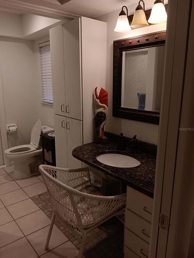 bathroom with tile patterned flooring, vanity, and toilet