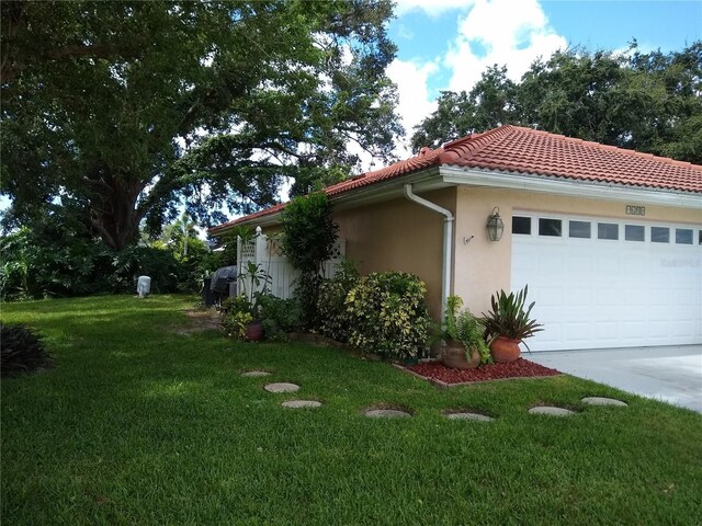 view of home's exterior with a garage and a yard