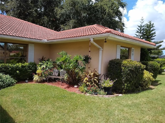 1608 Bob O Link Dr, Venice, FL 34293 - view of property exterior with a tiled roof, a yard, and stucco siding
