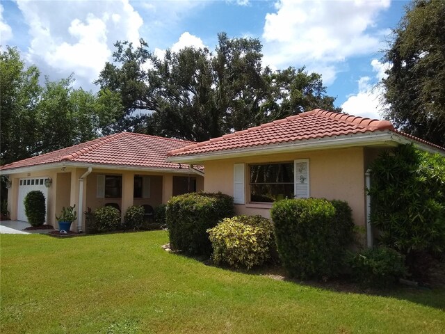 back of house with a lawn and a garage