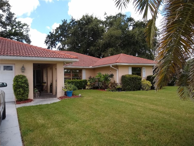 rear view of house featuring a lawn and a garage