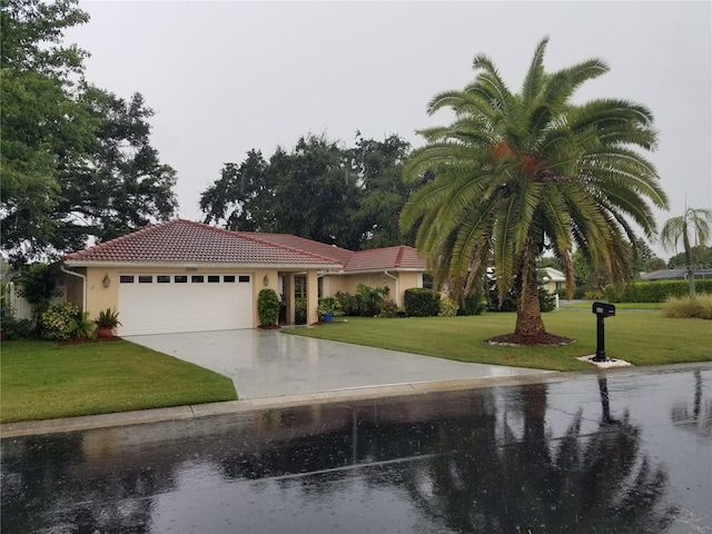 1608 Bob O Link Dr, Venice, FL 34293 - mediterranean / spanish-style home featuring a front lawn, concrete driveway, a tile roof, stucco siding, and a garage
