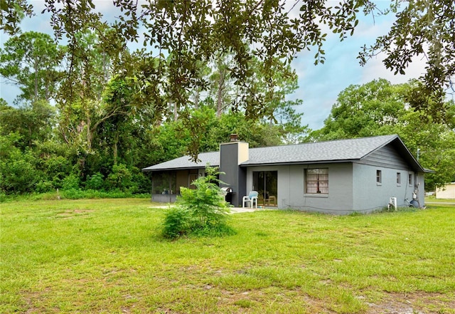 back of house with a sunroom and a yard