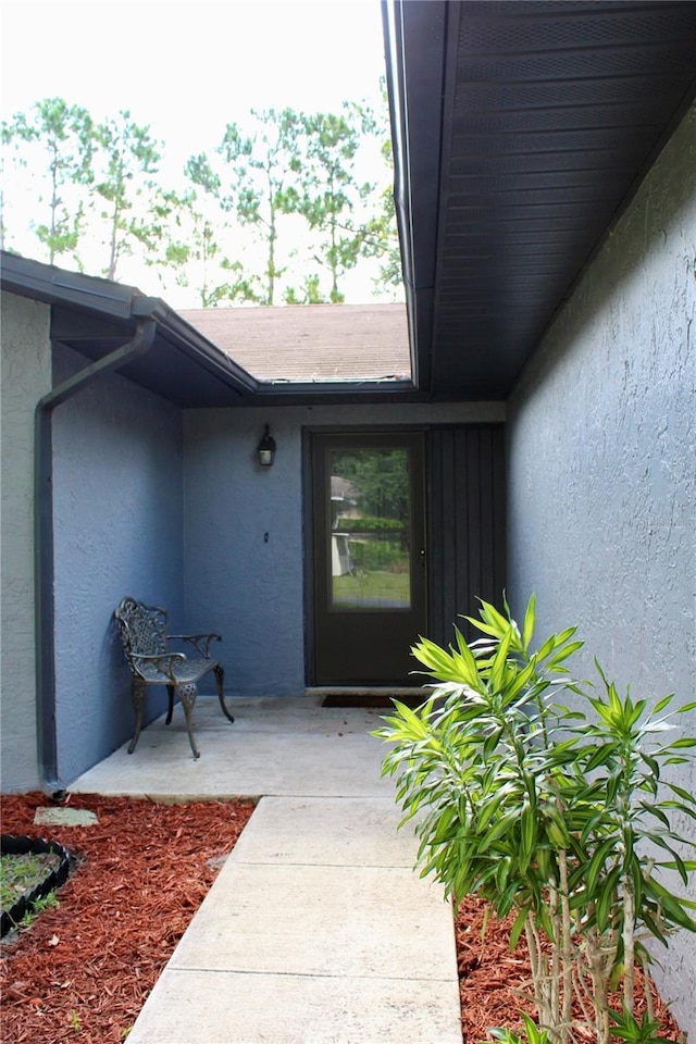 view of exterior entry with a patio