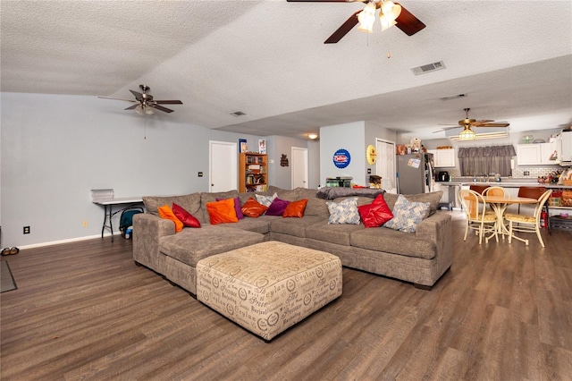 living room with vaulted ceiling, dark hardwood / wood-style flooring, and a textured ceiling