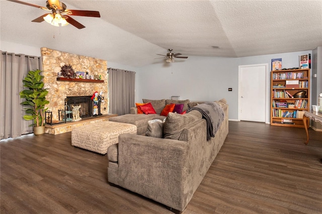 living room featuring ceiling fan, a fireplace, dark hardwood / wood-style floors, and a textured ceiling