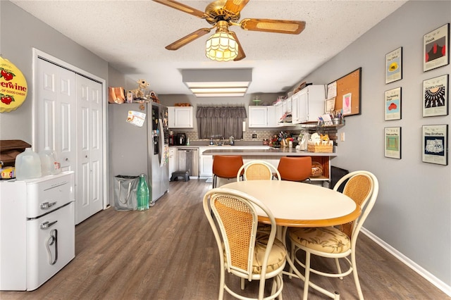 dining space featuring ceiling fan, dark hardwood / wood-style flooring, and a textured ceiling