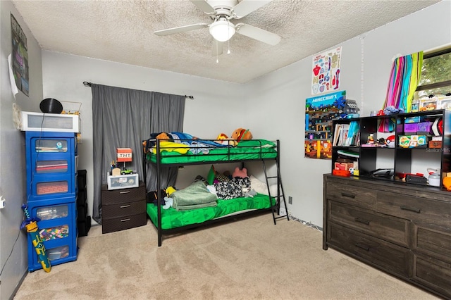 bedroom featuring a textured ceiling, light colored carpet, and ceiling fan