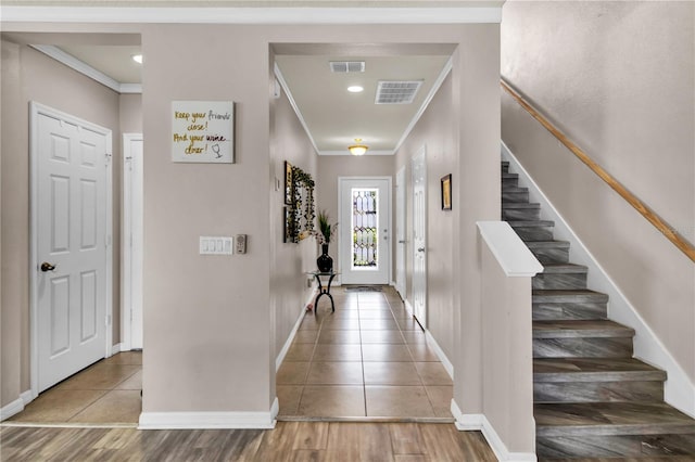 entryway with hardwood / wood-style floors and ornamental molding