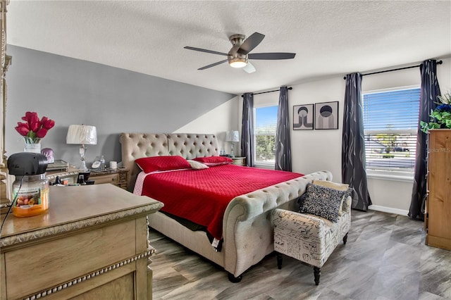 bedroom featuring multiple windows, a textured ceiling, and ceiling fan