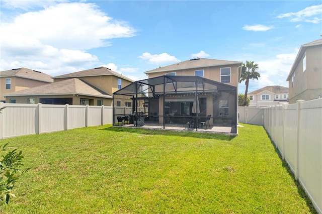 back of house featuring a lawn, a lanai, and a patio