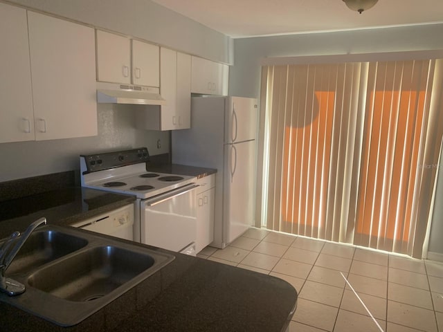 kitchen with white appliances, sink, light tile patterned flooring, and white cabinetry