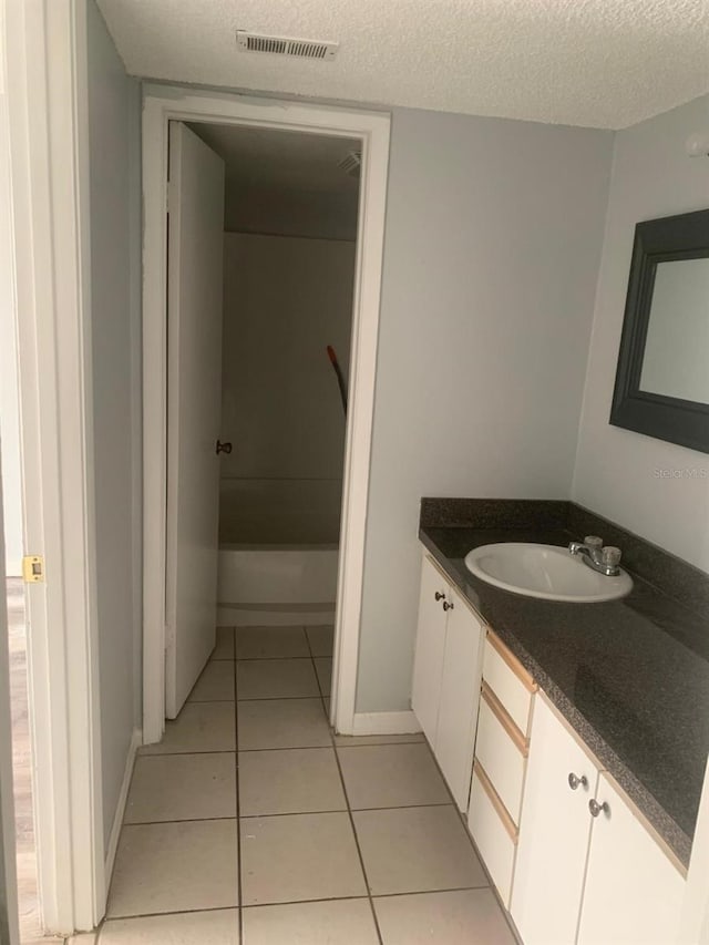 bathroom with tile patterned floors, a textured ceiling, vanity, and shower / tub combination